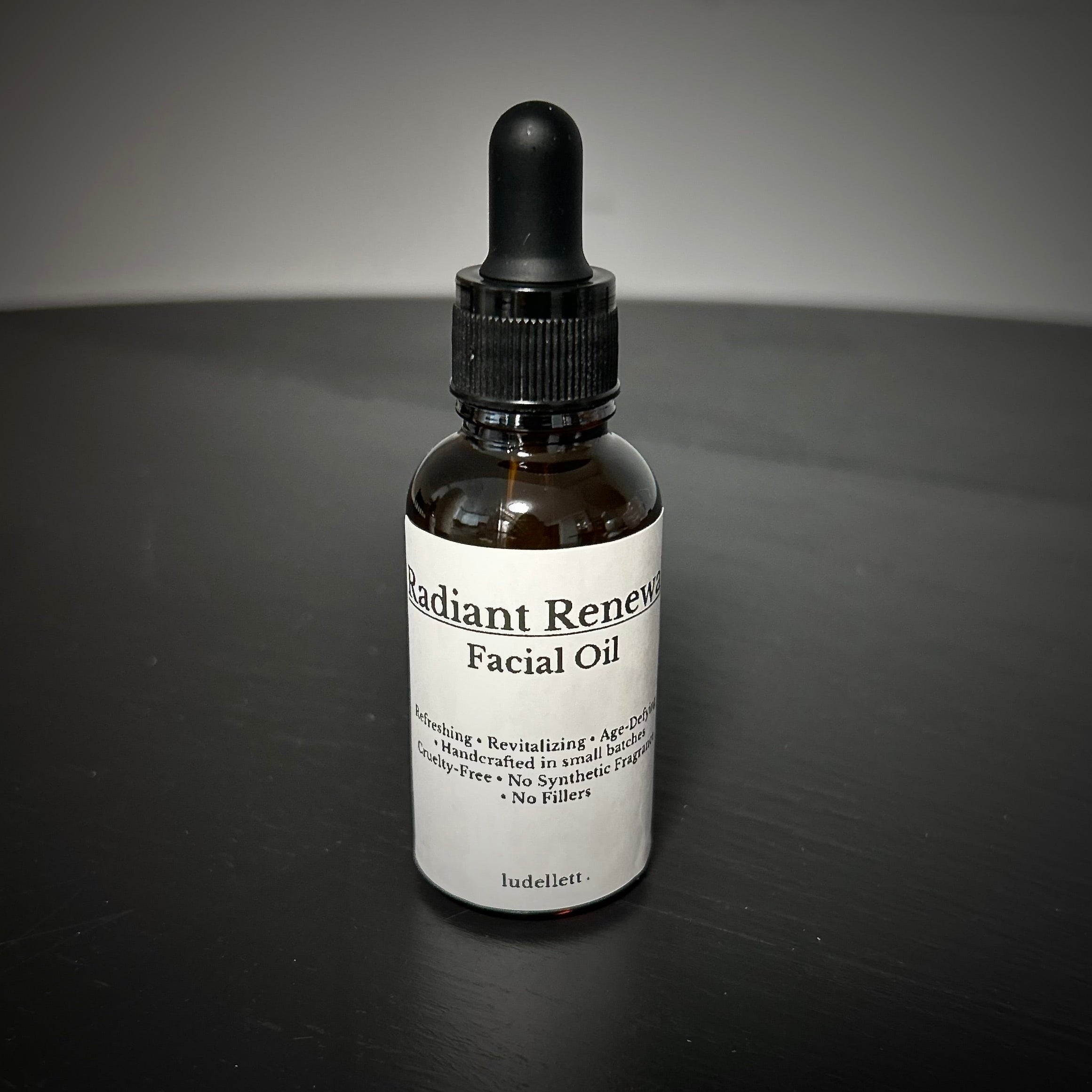 Facial oil bottle with dropper on a dark surface